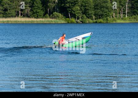 Aluksne, Lettland - 19. Juni 2021: Nicht identifizierte Menschen auf einem Motorboot auf dem See. Stockfoto