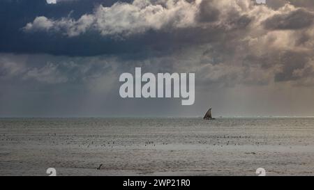 Ein traditionelles Segelboot aus Holz fährt entlang des Horizonts, Jambiani, Sansibar, Tansania. Stockfoto