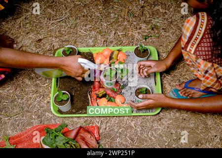 Die Kinder, die kompostiert und kompostiert werden, bewegen sich als Kompostierungsstapel aus verrottenden Küchenabfällen mit Obst- und Gemüseabfällen Stockfoto