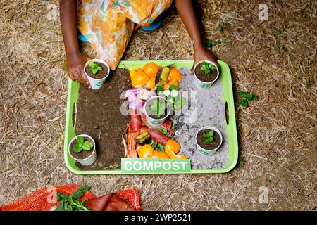 Die Kinder, die kompostiert und kompostiert werden, bewegen sich als Kompostierungsstapel aus verrottenden Küchenabfällen mit Obst- und Gemüseabfällen Stockfoto