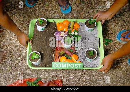 Die Kinder, die kompostiert und kompostiert werden, bewegen sich als Kompostierungsstapel aus verrottenden Küchenabfällen mit Obst- und Gemüseabfällen Stockfoto