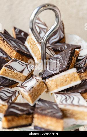 Vertikale Fotos kunstvoll marmorierte Schokolade schmückt diese verführerischen arabischen Leckereien. Jedes Stück ist eine perfekte Mischung aus Tradition und Gourmet, die auf einem Elg präsentiert wird Stockfoto