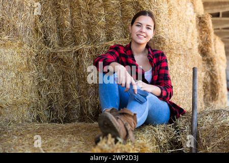 Frau, die auf dem Bauernhof bei Strohhalmen posiert Stockfoto