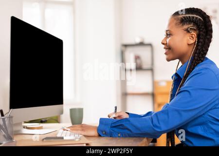 Zielgerichtete Schülerin, die zu Hause mit dem Computer online lernen möchte Stockfoto