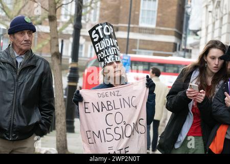 London, Großbritannien. 5. März 2024. Umweltaktivisten protestieren vor dem Department for Energy Security and Net Zero (DESNZ) gegen die Pläne der Regierung, weitere öffentliche Subventionen für die Baumverbrennungskraftwerke Drax in Yorkshire und Lynemouth in Northumberland zu gewähren. Das ehemalige Kohlekraftwerk Drax, das bereits umfangreiche öffentliche Zuschüsse erhält, verbrennt importierte Holzpellets, auch von Bäumen, die in alten Primärwäldern gefällt wurden, und ist einer der größten CO2- und Feinstaubemittenten (PM10) im Vereinigten Königreich. Kritiker bestreiten auch seinen Anspruch, eine "erneuerbare" Energiequelle zu sein. Stockfoto