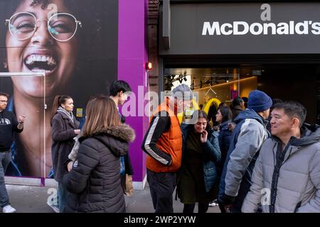 Menschen vor McDonalds in der Oxford Street am 3. März 2024 in London, Großbritannien. McDonalds ist ein US-amerikanisches Fast-Food-Unternehmen, das 1940 gegründet wurde und 1953 das Golden Arches Logo eingeführt hat. Stockfoto