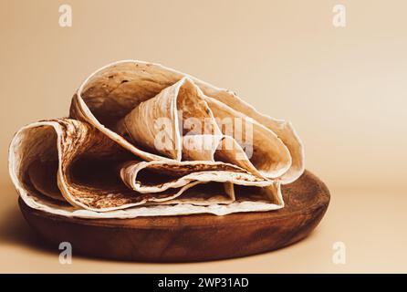 Dünnes gebratenes Fladenbrot liegt auf einem Holzteller Stockfoto