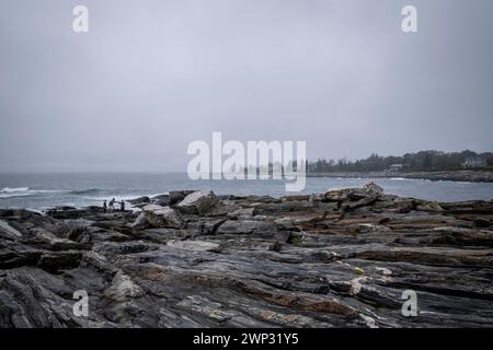 Pemaquid Point, Maine mit bewölktem Himmel und den massiven Felsvorsprüngen im Vordergrund. Stockfoto