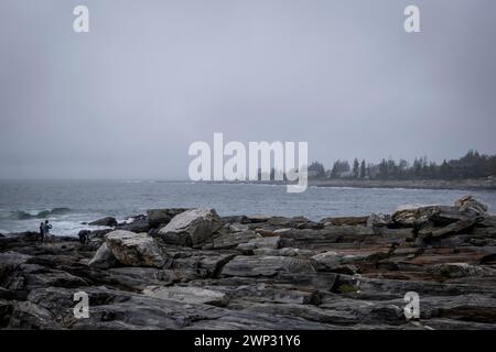 Pemaquid Point, Maine mit bewölktem Himmel und den massiven Felsvorsprüngen im Vordergrund. Stockfoto