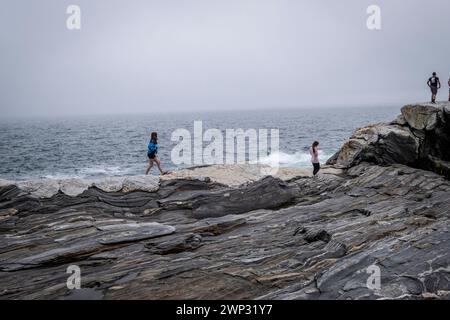 Pemaquid Point, Maine mit bewölktem Himmel und den massiven Felsvorsprüngen im Vordergrund. Stockfoto