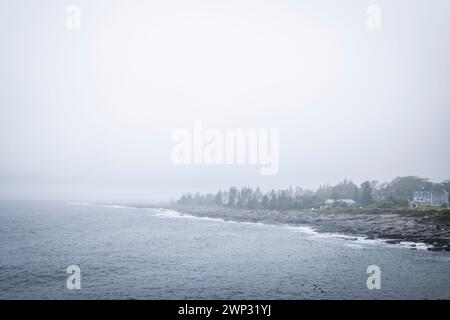 Pemaquid Point, Maine mit bewölktem Himmel und den massiven Felsvorsprüngen im Vordergrund. Stockfoto