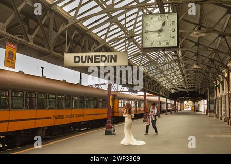 Eine Braut posiert auf einem Bahnsteig am Bahnhof Dunedin im Zentrum von Dunedin, Neuseeland. Stockfoto