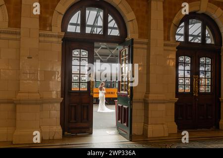 Eine Braut posiert auf einem Bahnsteig am Bahnhof Dunedin im Zentrum von Dunedin, Neuseeland. Stockfoto
