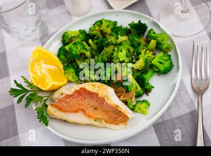 Appetitlich geröstetes Steinfischfilet mit gebratenem Brokkoli Stockfoto