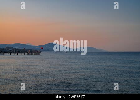 Wunderschöne Sonnenaufgangsszene am Strand von Alanya mit Blick auf die berühmte Insel Alanya in der Türkei Stockfoto