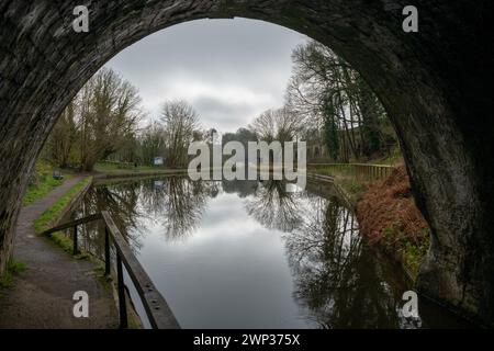 Blick aus dem Eingang des Chirk-Tunnels auf den Llangollenkanal mit der Krümmung des Tunnels, der den Kanal und die Landschaft dahinter umrahmt. Stockfoto