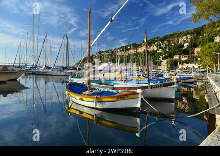 Malerische traditionelle Fischerboote, bekannt als pointus, liegen im wunderschönen Hafen von Villefranche-sur-Mer, Südfrankreich Stockfoto