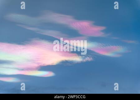 Schillernde Wolken (Regenbogenwolken) schließen sich am Abend Stockfoto