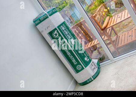 Unbenutzte Rolle Knauf 200 mm Super-up feuerfeste Loft-Isolierung stehend in einer Ecke. Stockfoto