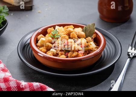 Ropa vieja, typisch kanarisches Gericht mit Kichererbseneintopf mit Huhn und Kartoffeln in einem Töpfertopf. Stockfoto