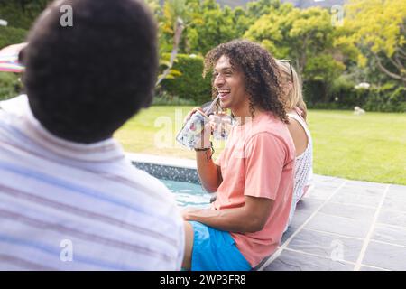 Junger afroamerikanischer Mann im Gespräch mit einem rassistischen Mann am Pool Stockfoto