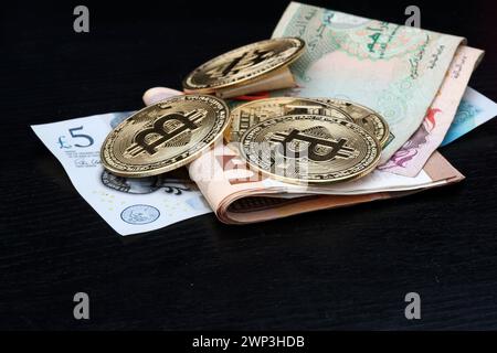 Symbolbild: Diverse Bitcoins auf Geldscheinen: Pfund, Euro und Dirham - die Alternative für Weltwährungen? - Der Bitcoin steht hoch im Kurs. Selbst F Stockfoto