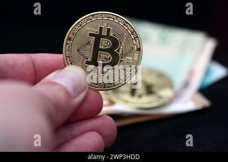 Symbolbild: Eine Hand hÃ¤lt einen Bitcoin - der Bitcoin steht hoch im Kurs. Stockfoto