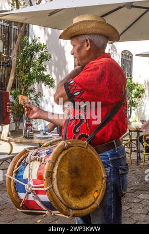 Ein Schlagzeuger in einer dominikanischen Merengue-Band im Columbus Park in der Kolonialstadt Santo Domingo, Dominikanische Republik. Merengue tipico oder Volksmusik ist t Stockfoto