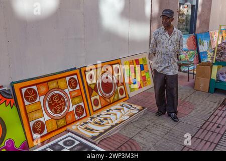 Ein Künstler verkauft seine Gemälde in der El Conde Street in der Kolonialstadt Santo Domingo, Dominikanische Republik. UNESCO-Weltkulturerbe der Kolonie Stockfoto