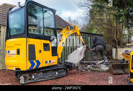 Bauarbeiten von Arbeitern in einer Auffahrt zum Entfernen von Beton, Schottland, Großbritannien Stockfoto