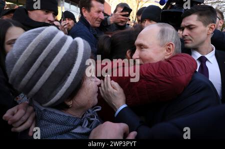 Solnechnodolsk, Russland. März 2024. Der russische Präsident Wladimir Putin, rechts, wird von einem Bewohner nach einer Tour durch die Gewächshäuser von Solnechni dar am 5. März 2024 in Solnechnodolsk, Stavropol-Territorium, Russland, umarmt. Quelle: Mikhail Metzel/Kreml Pool/Alamy Live News Stockfoto