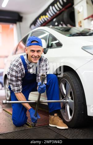 Der qualifizierte Mechaniker wechselt die Reifen des Fahrzeugs im Autodienst Stockfoto