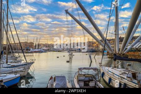 GENUA, ITALIEN - 20. MÄRZ 2021: Blick auf den Hafen von Genua mit Porto Antico, Booten und den farbenfrohen Häusern an der italienischen Küste. Stockfoto