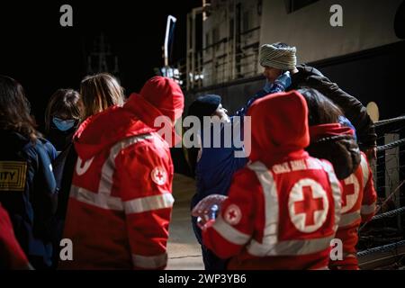 Crotone, Italien. März 2024. Ein Mitglied des Roten Kreuzes sah, wie er einem Migranten half. Das Rettungsschiff Humanity 1 der deutschen Nichtregierungsorganisation SOS Humanity kam am Samstag, den 2. März 2024, mit 77 Migranten, hauptsächlich aus Bangladesch und Pakistan, in den Hafen von Crotone an. Berichten zufolge wurden während der Rettungseinsätze die Besatzung und das Volk von der libyschen Küstenwache bedroht. (Foto: Valeria Ferraro/SOPA Images/SIPA USA) Credit: SIPA USA/Alamy Live News Stockfoto