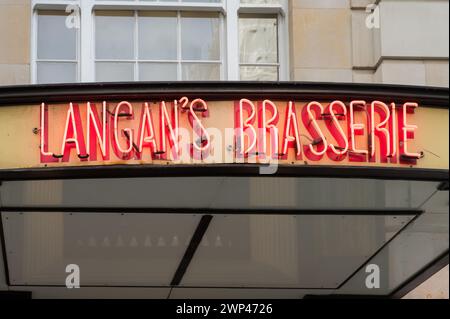 Neonlicht-Schild über dem Haupteingang des Langan's Brasserie Restaurants an der Stratton Street, Piccadilly, London, England, Großbritannien Stockfoto