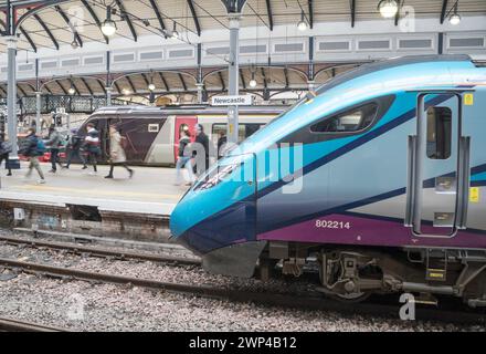 Die Bewegung verschwommen Passagiere, die einen Tanspennine Express-Zug im Bahnhof Newcastle Central, England, Großbritannien, verlassen Stockfoto