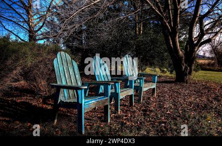 Drei Holzstühle stehen in einem ländlichen Park Stockfoto