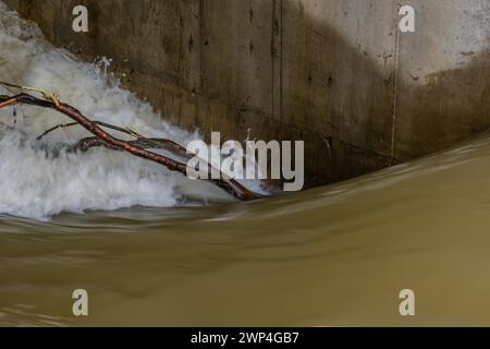 Der Baumzweig wurde neben der Stützsäule des Dammes gehalten, indem er Wasser durch das Schleusentor in Daejeon, Südkorea, strömte Stockfoto
