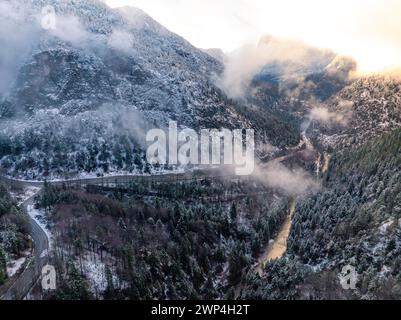 Luftaufnahme einer kurvenreichen Straße durch einen winterlichen Wald in den Bergen bei Dämmerung, Alpenstraße, Bad Reichenhall, Deutschland Stockfoto