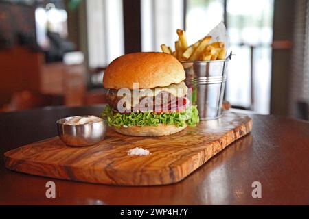 Cheers beladener Beef Burger mit Pommes Stockfoto