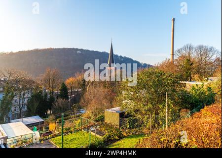 Sonnenaufgang über einer Stadt mit Kirchturm, Herbstbäumen und einem Industriegebiet im Hintergrund, Arrenberg, Elberfeld, Wuppertal, Bergisches Land Stockfoto