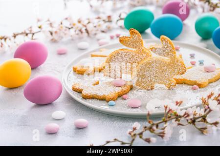Hausgemachte Mandelhasen-Kekse für Ostern mit bunten Ostereiern Stockfoto