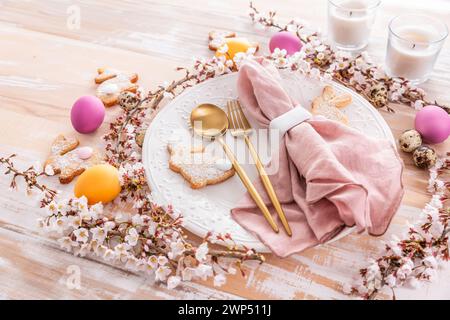 Ostertisch mit bunten Eiern und hausgemachten Häschen-Keksen Stockfoto