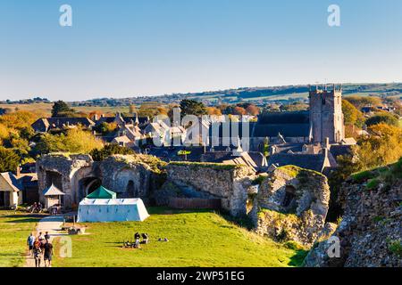 Blick auf Corfe Castle Village, Burgruinen und St. Edward, King & Martyr Church, Dorset, England Stockfoto