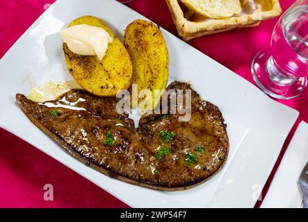 Leckere Kalbsleber mit gebackenen Kartoffeln auf dem Teller serviert, spanisches Gericht Stockfoto