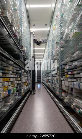 Fotos von einem Apothekenlagerraum und einer Roboterhand arrangieren und lagern Medikamente in einer Apotheke. Stockfoto