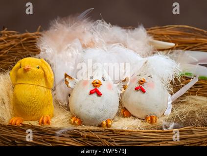 Babygelb Osterspielzeug Küken und Eier auf einem Hintergrund aus Federn. Stockfoto
