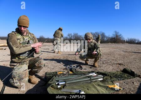 US-Soldaten von Bravo Battery, 1. Bataillon, 182nd Field Artillery Regiment, Michigan Army National Guard, demontieren eine Funkantenne vom Battery Operations Center für ein M142 High Mobility Artillery Rocket System (HIMARS), nachdem sie am 2. März 2024 eine Live-Feuerübung im Camp Grayling Michigan absolviert hatten. Die Mitglieder des Referats führten eine Qualifikation nach Tabelle VI für die Leiter der Sektionen durch. (Foto der Nationalgarde der US-Armee von Daniel Garas) Stockfoto