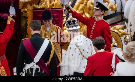 König Karl III. Krönung, verlässt Westminster Abbey an Bord des Gold State Coach, nach seiner Krönung am 6. Mai 2023. Er trägt die Krone des Staates (Imperial State Crown), uniformierte Wachen halten Regenschirme, um den König vor Regen zu schützen. Westminster Abbey Westminster London UK Stockfoto