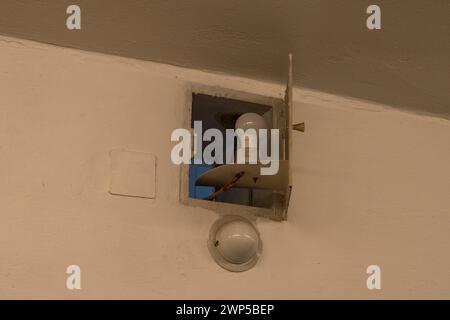 Zellenlicht an einer kleinen Falltür im Zellflügel des ehemaligen Stasi-Gefängnisses Hohenschönhausen, Berlin. Stockfoto